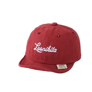 Dark red cotton baby baseball cap with white cursive embroidery and soft brim detail