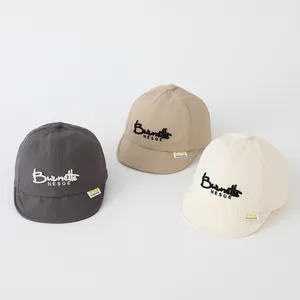Detail of soft brim baby baseball caps with SMILE embroidery in grey, khaki and beige