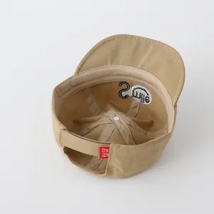 Inside view of khaki baseball cap showing Smile pattern and adjustable velcro strap