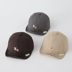 Nahaufnahme von schnelltrocknenden Baby-Basecaps in Braun, Grau und Beige mit Stickereien