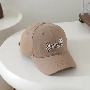 Close-up of Insbobo bear embroidery and letter detailing on khaki cotton baseball cap