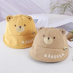 Close-up of cute infant sun hats with bear ears and happy embroidery in yellow and khaki