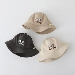 Dettaglio di tre cappelli da pescatore in cotone per bambini con ricamo di orsetto