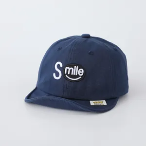 Detailed view of navy cotton baby cap with white SMILE embroidery and premium stitching