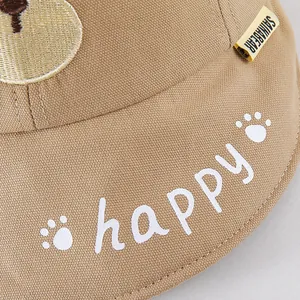 Detail of khaki cotton baby sun hat with happy print and cute bear embroidery patch