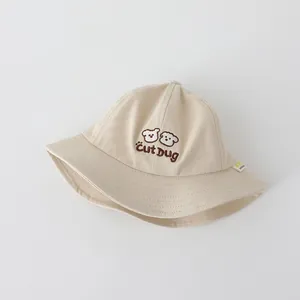 Dettaglio cappello pescatore beige per bambini con ricamo di cucciolo e trama in cotone