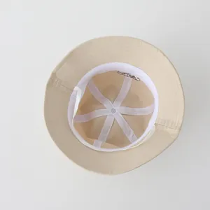 Dettaglio interno di un cappello da sole beige con cuciture bianche e fascia antisudore