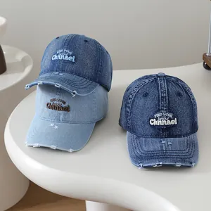 Vue détaillée d'une casquette en denim délavé avec broderie 3D et bords usés stylés