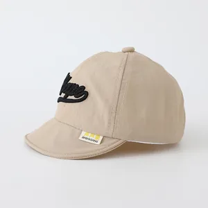 Detail of baby sun hat featuring embroidered 'Super' text and brand woven label on soft brim