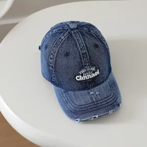 Vue détaillée de la casquette en denim bleu foncé avec broderie blanche effet vieilli