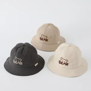Dettaglio ricamo orso su cappelli da pescatore in cotone in tre colori diversi