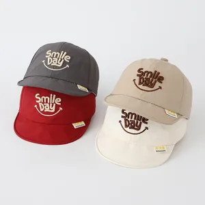 Detail view of colorful soft brim baby caps with SMILE DAY embroidery and brand tag