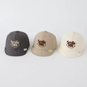 Detailed embroidery of Smile Day text on soft-brimmed baby baseball caps in three colors