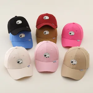 Detail of embroidered sheep patches on various colored cotton baseball caps for kids