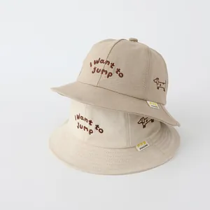 Dettaglio di cappelli a secchiello per bambini in cotone con ricami e testo ricamato