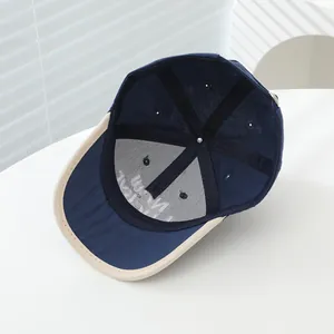 Detailopname van marineblauwe en beige kinderpet met de binnenkant en stikselnaden