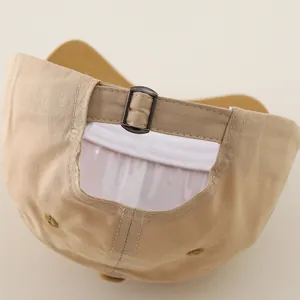Detail of adjustable metal buckle and breathable eyelets on light khaki cotton baseball cap