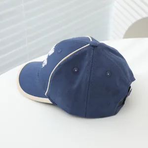 Detailweergave van de marineblauwe baseballpet met wit borduursel en metalen gesp