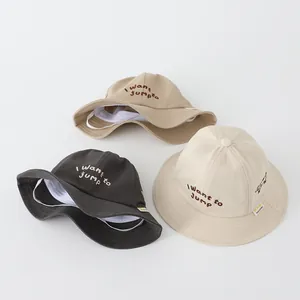 Dettaglio di cappelli da sole in cotone per bambini in cachi, grigio e beige con ricamo