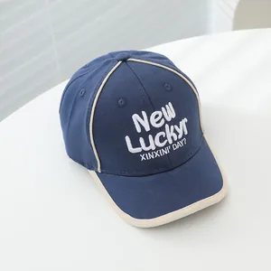 Marineblauwe en beige kinder honkbalpet met New Luckyr borduursel in zijaanzicht getoond