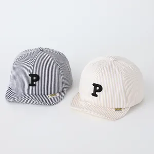 Close-up of baby striped baseball caps with embroidered P letter and soft fabric texture