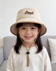 Detail of beige kids bucket hat with Best YM.CO embroidery and adjustable windproof cord