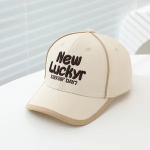 Detail van beige katoenen baseballpet met bruine New Luckyr 3D-borduring voorop