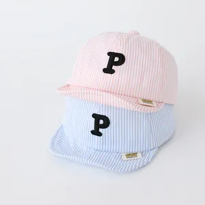 Detail of baby striped baseball caps with embroidered P letter and soft cotton fabric