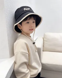 Detail of kids black sun hat with Best VM.CO embroidery and beige trim plus wind strap
