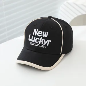 Detail van het LUCKY borduursel en contrastpijpjes op de zwarte katoenen honkbalpet