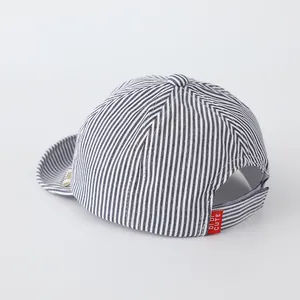 Close-up of baby baseball cap with blue stripes and adjustable velcro strap back