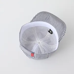 Detail view of baby striped baseball cap showing soft inner lining and red brand label