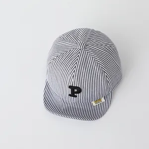 Detail of baby striped baseball cap with embroidered P letter and yellow brand tag