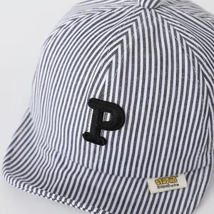 Detailed macro view of cotton striped baby hat with embroidered P letter and woven label