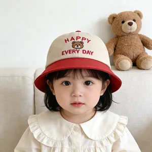 Detail of happy bear embroidery and red text on two-tone kids cotton bucket sun hat