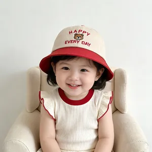 Detail of baby bucket hat with Happy Every Day bear embroidery and ruffle trim top