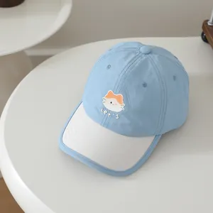Detailed view of kids cartoon cat embroidery on a light blue baseball sun hat