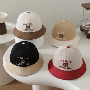 Detail view of cotton bucket hats for kids with bear embroidery in four mixed colorways