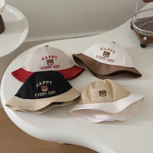 Flat lay of baby sun hats in four colors with bear embroidery and Happy Every Day text