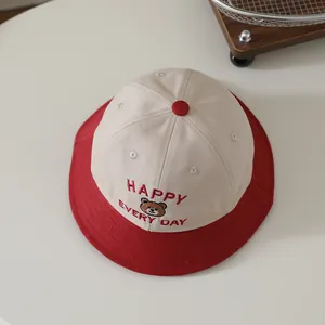 Detailed embroidery of a cartoon bear and Happy letters on a toddler bucket hat
