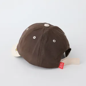 Detail of baby baseball cap showing back adjustable strap and brand woven label