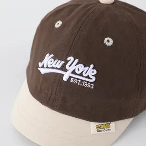 Detailed close-up of New York embroidery and stitching on a two-tone cotton kids baseball cap