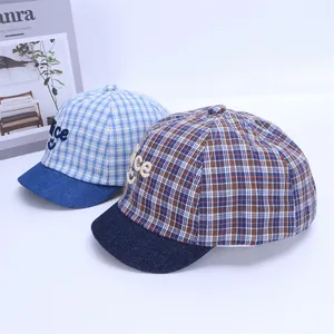 Detail view of plaid baby baseball caps with Nice smile embroidery and denim brim