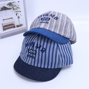 Detail of striped baby baseball caps with NICE smiley face and soft denim brim texture