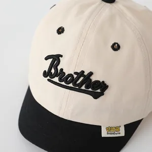 Detalle del texto Brother bordado en una gorra bicolor con textura de lona