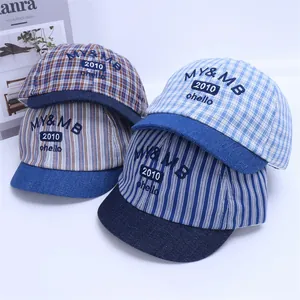 Close-up of baby baseball caps in striped and plaid patterns with soft denim brims