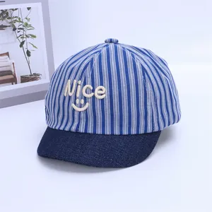 Close-up of baby baseball cap featuring blue stripes and white Nice smile embroidery