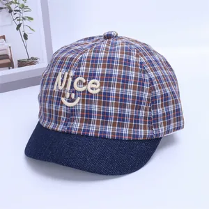 Close-up of baby baseball cap with plaid pattern and embroidered Nice smiley face