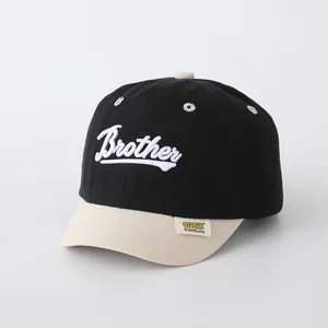 Detalle de gorra infantil bicolor con bordado Brother y visera beige de contraste