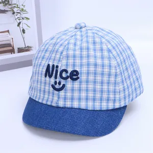 Detail of baby striped baseball cap with Nice smiley embroidery and blue denim brim